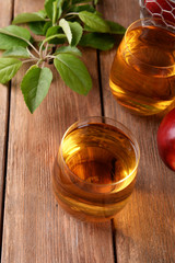 Glasses of apple juice on wooden table, closeup