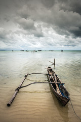 Fisherman boat at the seashore on a cloudy day