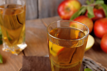 Glasses of apple juice on wooden background