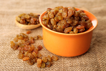 Raisins in pan on sackcloth, closeup