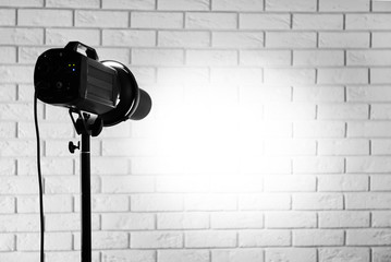 Photo studio with lighting equipment on brick wall background