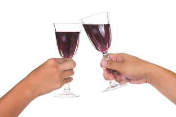 Hands toasting red wine in crystal glasses