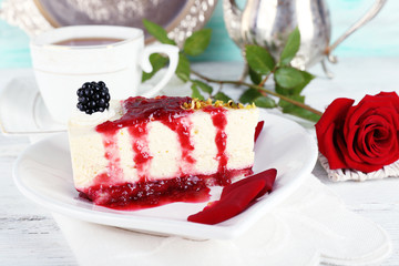Tasty piece of cheesecake with berry sauce on plate on table close up