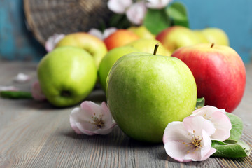 Fresh apples with apple blossom on wooden table