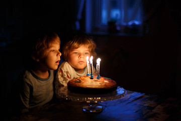 little boys celebrating  birthday and blowing candles on homemad