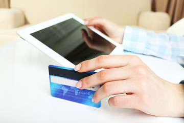 Female hands with tablet and credit card as online shopping concept