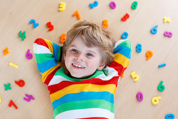 Fototapeta na wymiar Kid boy with colorful numbers, indoor