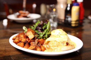 Crab cake Benedict with potatoes and salad.