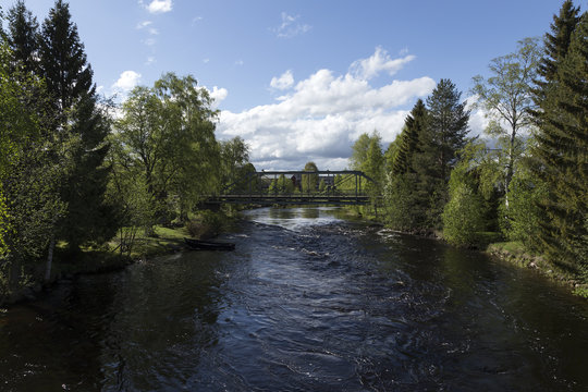 A bridge and a small stream with a little boat in it 