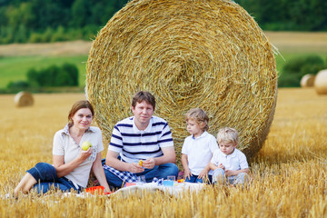 Naklejka na ściany i meble Mother, father and two little sons having picnic