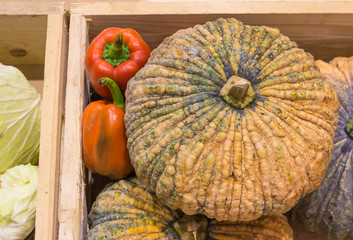 pumpkin and pepper harvested products on wooden box.