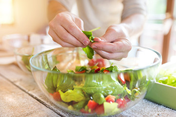 Unrecognizable young man preparing colorful vegetable salad