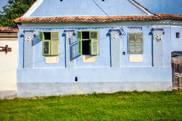 Fototapeta na wymiar Blue painted traditional house with green shutters from Viscri v