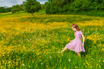 Fototapeta premium Little girl playing in buttercups field