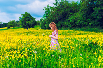 Little girl playing in buttercups field