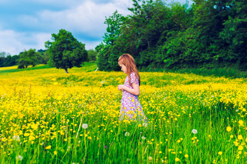 Fototapeta premium Little girl playing in buttercups field