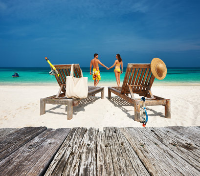 Couple in yellow relax on a beach at Maldives