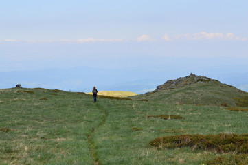 Fototapeta na wymiar Woman Walking On Wide Mountain Plateau