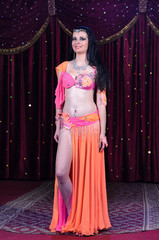 Belly Dancer in Colorful Costume Standing on Stage