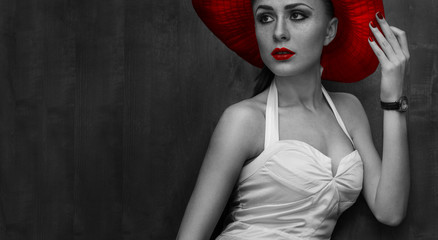 beautiful woman in hat with red lips posing before camera