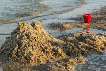 Ruined sand castle and children's bucket