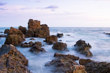 Fototapeta na wymiar Rock in sea with wave on sunset time