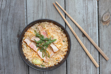 Bowl of oriental noodle and pork soup.