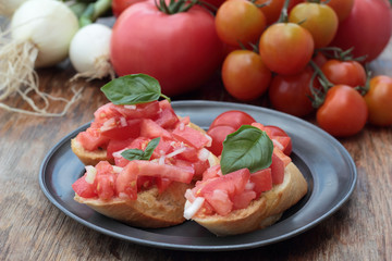 Three pieces of bruschetta on a tin plate.