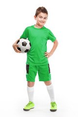 standing young soccer player holding football