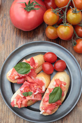 Three pieces of bruschetta on a tin plate.