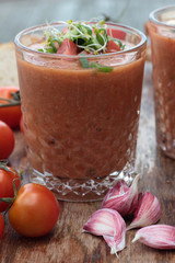 Two glasses of freshly prepared gazpacho with vegetable topping.