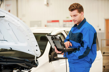Mechanic examining car. 