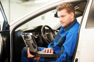Examining car with special computer. 