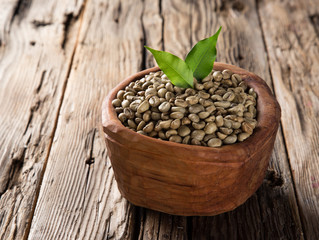 green coffee beans in wooden bowl