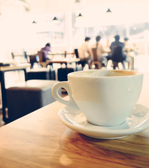 cup of coffee and blurred background of customer at cafe