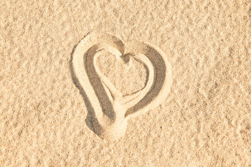 Close up of a heart sketched in the sand of a beach
