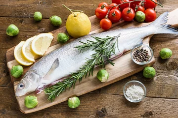 Crédence de cuisine en verre imprimé Poisson Fresh fish with vegetables on wooden board