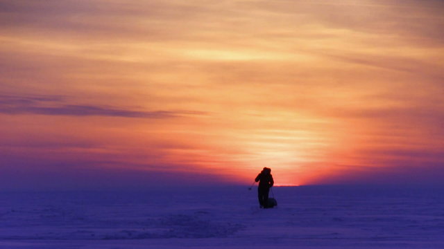 One man go to sunset on snow desert