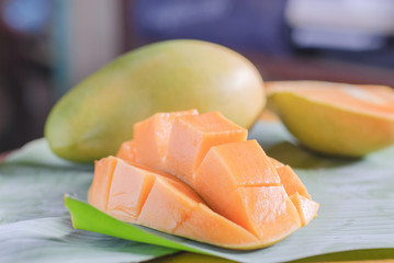 Ripe mango with slices on banana leaves