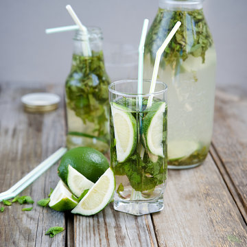 Lemonade with mint and lime on an old wooden table 