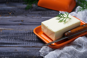 Fresh butter and knife on wooden background