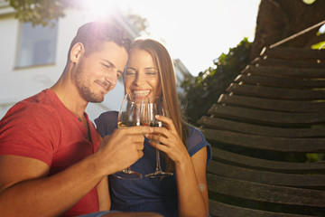 Couple celebrating with wine in backyard