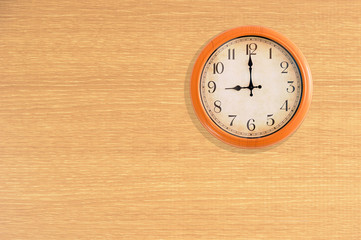 Clock showing 9 o'clock on a wooden wall