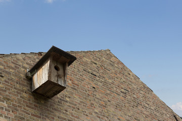 Fototapeta na wymiar Birds house - birdhouse on brick wall building