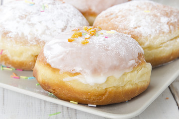 donuts with frosting and powdered sugar on a platter