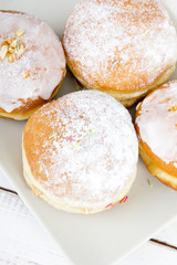donuts with frosting and powdered sugar on a platter