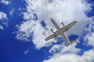 Fototapeta na wymiar Aircraft flying in blue cloudy sky