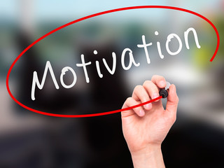 Man Hand writing Motivation with marker.