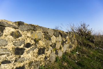 Fototapeta na wymiar Old stone fence and blue sky