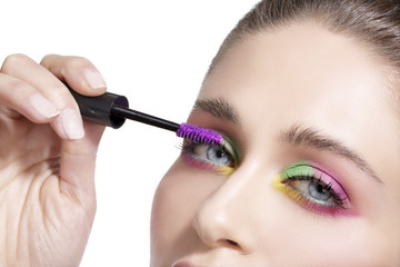 Close up on eyes , making colorful eyeshadows and eyeliner